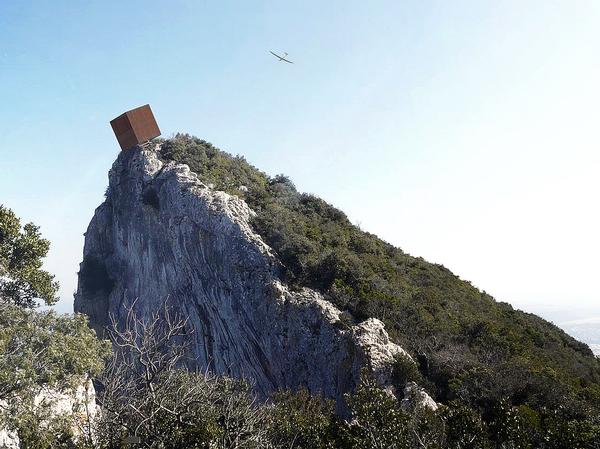 The cube appears to be about to tip over the edge of the cliff. It provide a space to rest and take in the views