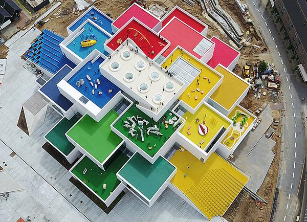 The Lego building is designed to look like a stack of Lego bricks, with a 2x4 brick on top